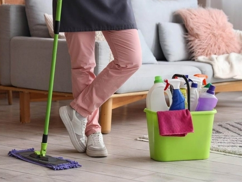 Woman holding a mop surrounded by various cleaning products at Starlinks